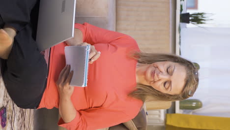 Vertical-video-of-Woman-with-notebook-thinks-and-takes-notes.